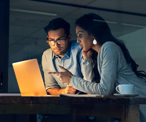 man and woman working on laptop